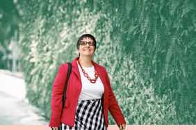Senior woman enjoying a walk in front of a vertical garden