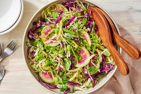 Cabbage & Edamame Salad with Peanut Dressing in a bowl with serving utensils