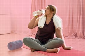 a woman drinking from a bottle of water while exercising