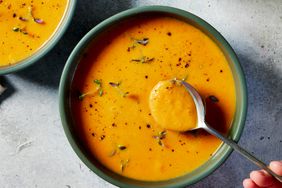 spoonful of carrot soup lifted out of bowl