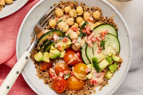 Chickpea & quinoa grain bowl in a white shallow bowl, with a fork on the left side