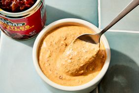 Chipotle sauce recipe in a small white serving bowl, with a spoon scooping some of the sauce up