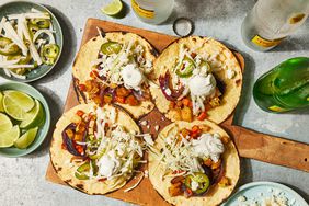 Overhead view of four tacos from The Best Vegetarian Tacos recipe on a wooden cutting board