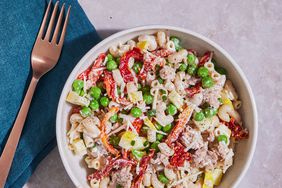 a bowl of sun-dried tomato, tuna and pea pasta salad