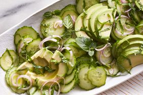 a white platter with cucumbers and avocados