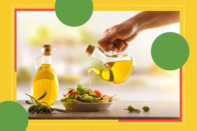 Person pouring olive oil onto a salad