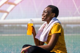 a photo of a woman drinking an electrolyte drink