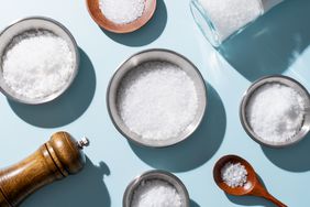 a photo of salt in bowls, spoons, and shakers