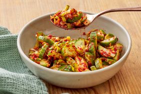 bowl of cucumber kimchi with a spoonful of kimchi being taken out