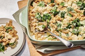 overhead view of Creamy Garlic-Parmesan Chicken and Spinach Pasta bake being served from a casserole dish