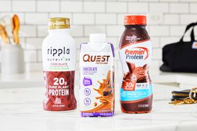 Three protein shake bottles on a kitchen counter