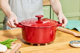 A person holding the handles of the Cuisinart Chef's Classic Casserole Dutch Oven