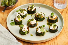 Zucchini Bites with Pesto & Burrata on a plate with small dish of pesto to the side