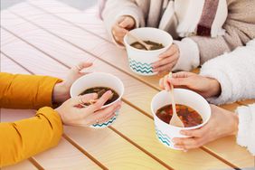 an image of three people eating take-out soup