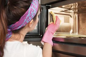 Woman cleaning a microwave oven