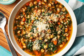 Hearty chickpea & spinach stew in a white bowl, with grated parmesan cheese sprinkled on top