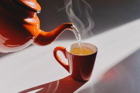 a photo of a kettle of boiled water being poured into a cup of tea