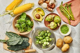 overhead photo of corn, mushrooms, brussels sprouts, artichokes, potatoes, avocados, kale, spinach