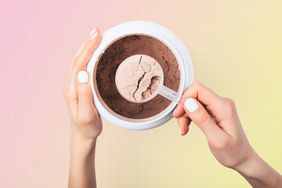 a photo of a person scooping out protein powder out of a container