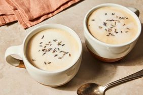 Two white cups with lavender latter in them, topped with lavender flowers