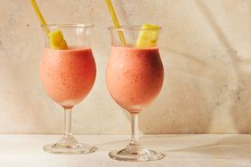 Two no-sugar-added frozen strawberry piÃ±a coladas, garnished with a pineapple slice and a yellow straw