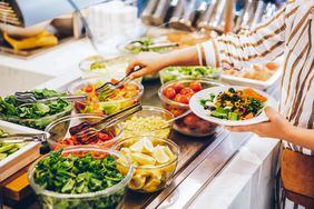 a photo of someone making a salad at a salad bar