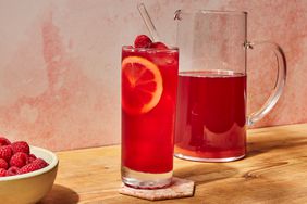 Side view of a glass and pitcher of No-Sugar-Added Raspberry Iced Tea recipe