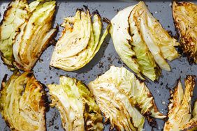 Overhead view of sliced cabbage finished roasting on a baking sheet from Roasted Garlic-Butter Cabbage Wedges recipe