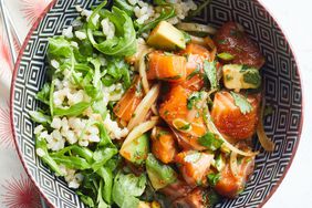 a bowl with salmon, avocado and greens