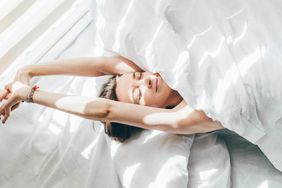 a photo of a woman stretching in bed