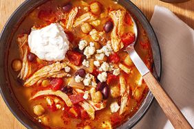 a recipe photo of Slow Cooker Buffalo Chicken Chili served in a bowl and topped with cheese and sour cream