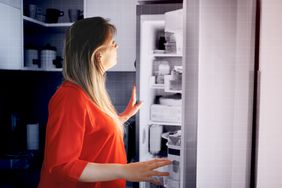 woman in front of the open fridge