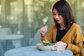 a photo of a woman eating a salad