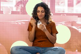 a photo of a woman enjoying a cup of yogurt while sitting on the couch