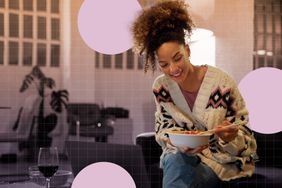 a photo of a woman enjoying dinner with a glass of wine while sitting on the couch 