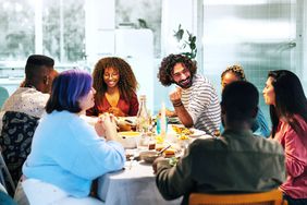 friends gathering around table having a dinner party