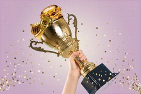 a photo of an arm holding up a trophy filled with golden foods like cupcakes, burgers, and donuts