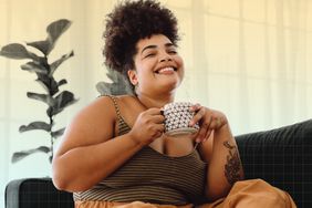 a photo of a woman enjoying a drink from a mug