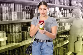 a photo of a woman reading the back of a can 